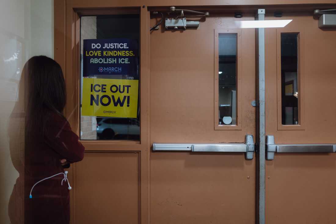 Une femme surveille la porte d'entrée de la clinique, un nouveau rôle que la clinique a assumé en raison des raids de l'ICE dans la ville.