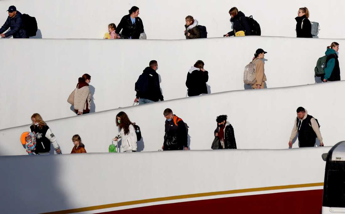 Des Ukrainiens demandeurs d'asile marchent au point d'entrée d'El Chaparral en route pour entrer aux États-Unis, au milieu de l'invasion russe de l'Ukraine, le 6 avril 2022 à Tijuana, au Mexique.