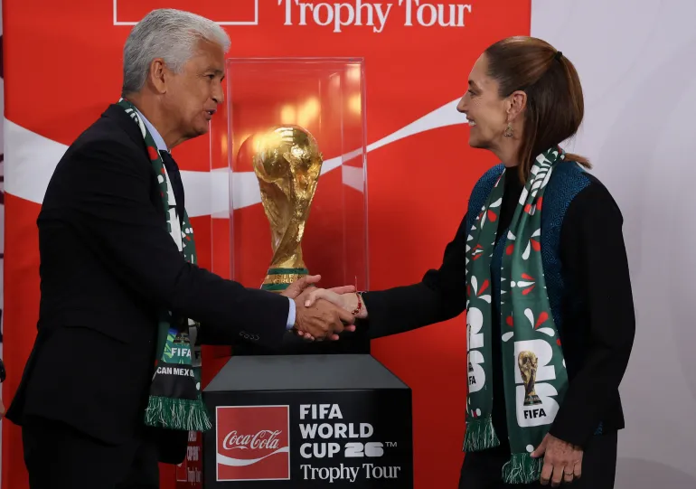 L'ancien footballeur brésilien José Roberto Gama de Oliveira 'Bebeto' serre la main de la présidente mexicaine Claudia Sheinbaum devant le trophée de la Coupe du Monde de la FIFA lors de sa conférence de presse matinale au Palais National, à Mexico.