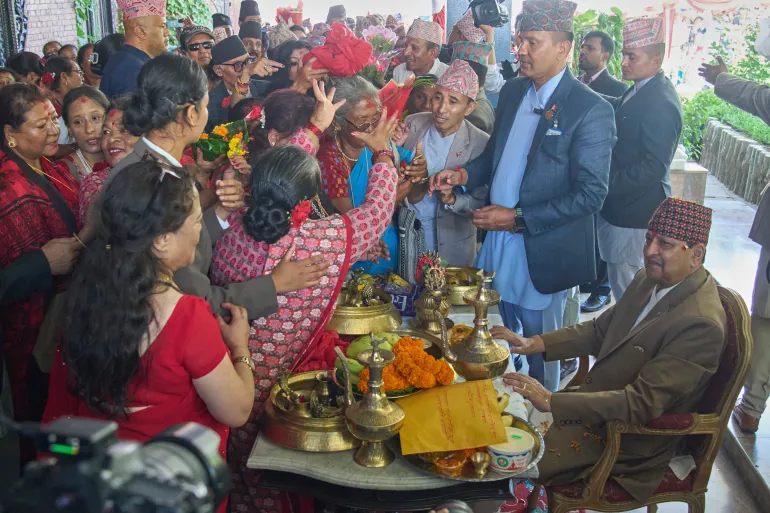 Des partisans accomplissent des rituels d'anniversaire pour l'ancien roi Gyanendra Shah, assis à droite, dans sa résidence à Katmandou, au Népal, le lundi 7 juillet 2025. (AP Photo/Niranjan Shrestha)