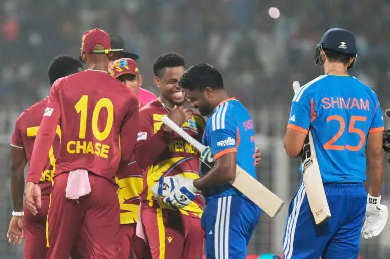 Shimron Hetmyer, au centre, des Antilles, discute avec l'Indien Sanju Samson après que l'Inde a remporté le match de cricket de la Coupe du monde T20 contre les Antilles à Calcutta, en Inde, le dimanche 1er mars 2026. (AP Photo/Bikas Das)