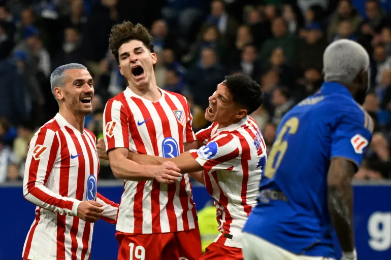 TOPSHOT - Atletico Madrid's Argentine forward #19 Julian Alvarez (C) celebrates with teammates French forward #07 Antoine Griezmann (L) and Argentine defender #16 Nahuel Molina Lucero after scoring a goal during the Spanish league football match between Real Oviedo and Club Atletico de Madrid at Carlos Tartiere Stadium in Oviedo on February 28, 2026. (Photo by ANDER GILLENEA / AFP)