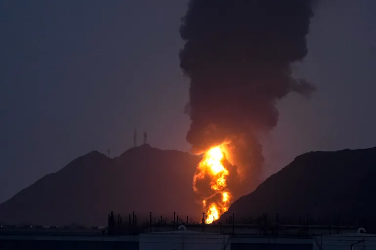 Un grand incendie et un panache de fumée sont visibles après que, selon les autorités, les débris d'un drone iranien intercepté ont frappé l'installation pétrolière de Fujairah, à Fujairah, aux Émirats arabes unis, le mardi 3 mars 2026. (AP Photo/Altaf Qadri)