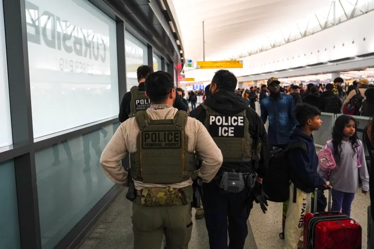 Des agents fédéraux de l'immigration traversent le terminal 5 de l'aéroport international John F. Kennedy (JFK) dans le quartier Queens de New York, le lundi 23 mars 2026. (AP Photo/Ryan Murphy)