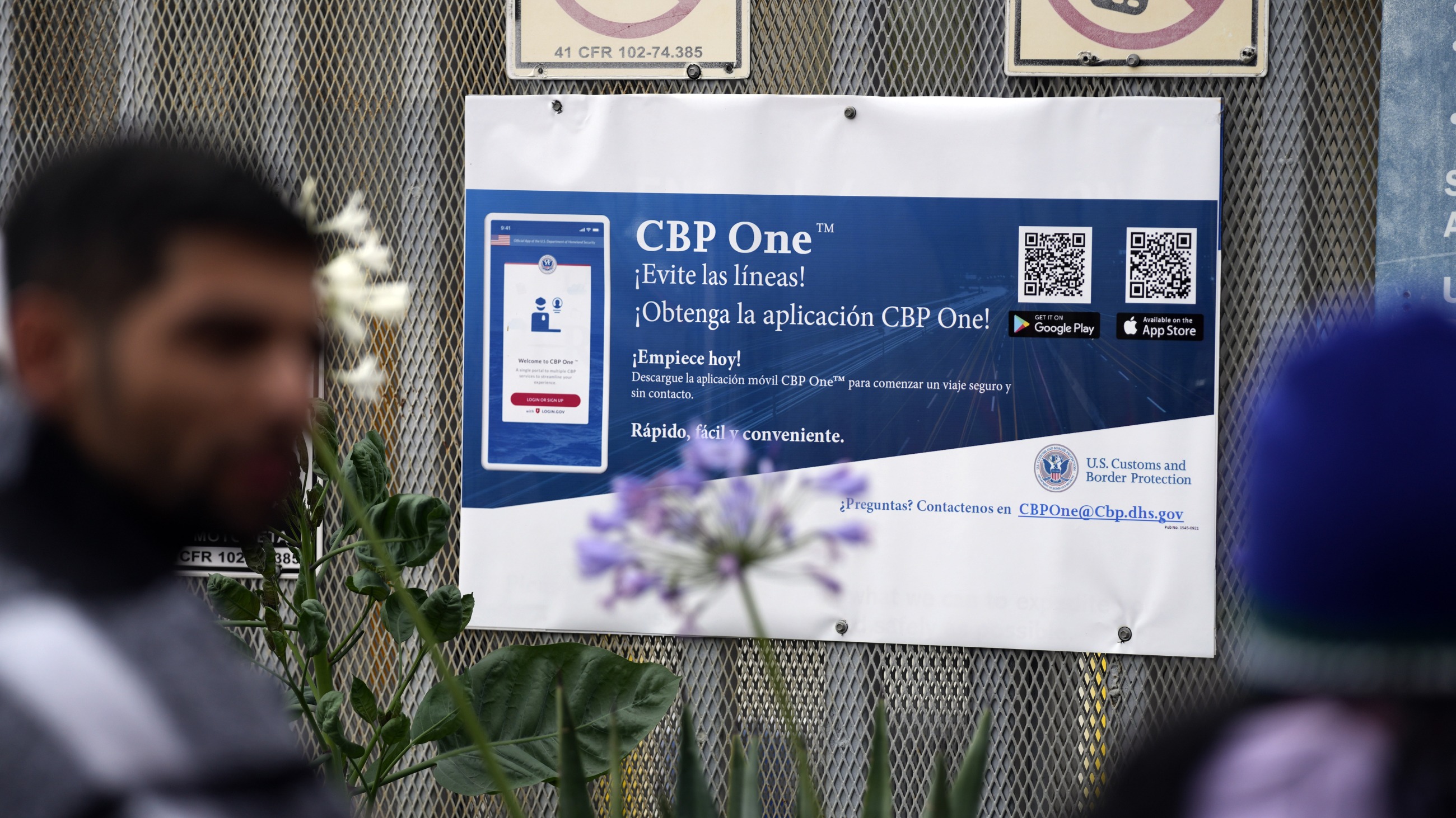 Les personnes en attente de demande d'asile se tiennent devant un panneau indiquant l'application CBP One alors qu'elles campent près de l'entrée piétonne du port d'entrée de San Isidro, reliant Tijuana, au Mexique, à San Diego.