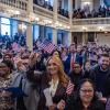 Les nouveaux citoyens américains, brandissant des drapeaux américains et alignés, participent à une cérémonie de naturalisation au Faneuil Hall de Boston le 8 janvier.