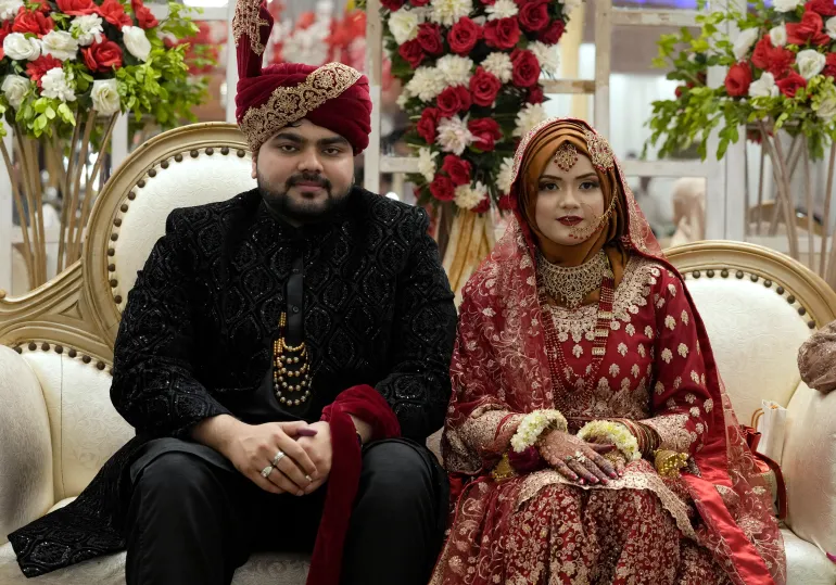 La mariée pakistanaise Dua Khan et son marié Asher Khan posent pour une photo lors de leur cérémonie de mariage dans la salle de banquet Radiance, à Karachi, au Pakistan, le samedi 27 janvier 2024. Il y a une mêlée de personnes essayant de prendre des photos avec le couple marié dans la salle de banquet Radiance, dans un quartier de classe moyenne de Karachi. Les voix sont à peine audibles au-dessus du vacarme des 400 invités, du service du dîner, de la musique et du vrombissement du drone dans la pièce. Les mariés sont rayonnants. Leurs familles et amis se bousculent pour une place avec eux sur scène. (Photo AP/Fareed Khan)