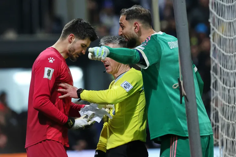 Le gardien bosniaque Nikola Vasilj, à gauche, et le gardien italien Gianluigi Donnarumma se disputent lors d'une séance de tirs au but lors de la finale des éliminatoires de qualification pour la Coupe du monde de football entre la Bosnie et l'Italie à Zenica, en Bosnie, le mardi 31 mars 2026. (AP Photo/Armin Durgut)
