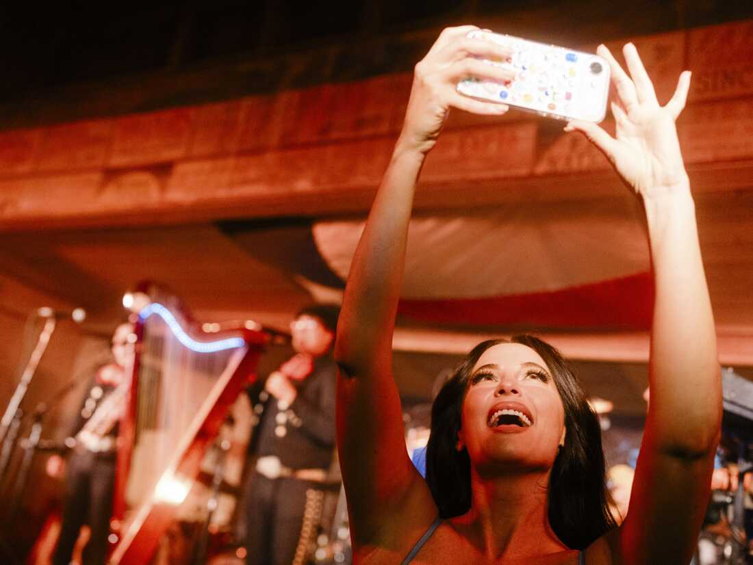 Kacey Musgraves enregistre la foule lors de la représentation des Mariachi Brothers et de leur père Luis Antonio Gámez, lors de son concert à guichets fermés au Gruene Hall de New Braunfels, Texas.