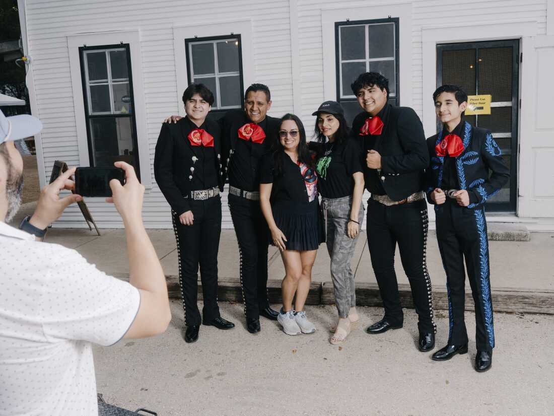 Antonio, Caleb et Joshua Gámez-Cuéllar avec leur père Luis Antonio Gámez, posent pour des photos avec les membres du Mariachi Las Coronelas au Gruene Hall à New Braunfels, Texas, le 4 mai 2026.