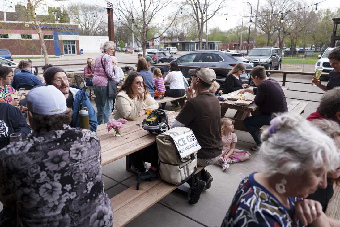 Les invités se mêlent sur une terrasse lors d'une collecte de fonds d'entraide organisée par Juntos Podemos à Arbiter Brewing Company à Minneapolis, Minnesota, le 23 avril 2026. L'événement a permis de recueillir environ 15,000 dollars pour soutenir les membres de la communauté qui continuent d'être touchés par les mesures fédérales d'immigration à la suite de l'opération Metro Surge.