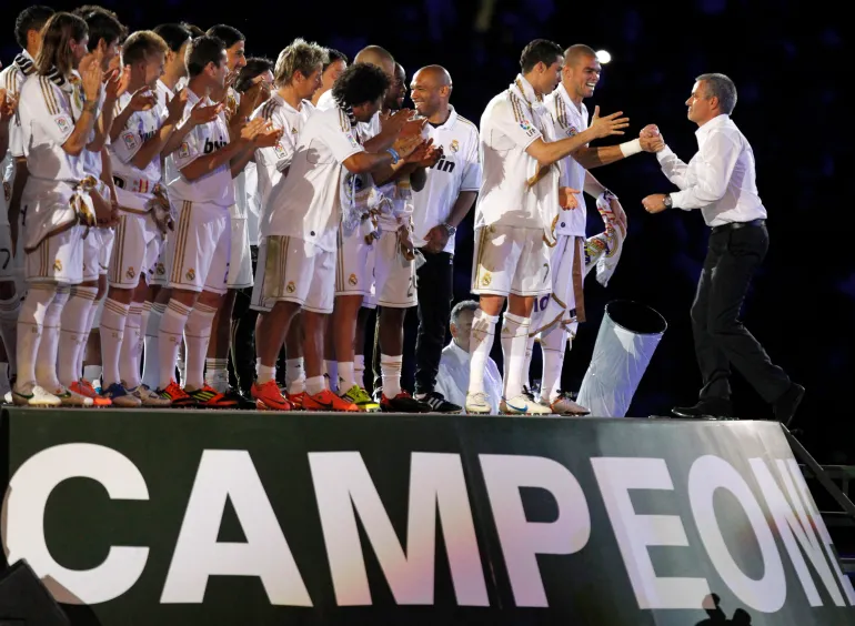 L'entraîneur du Real Madrid, José Mourinho (à droite), serre la main de Pepe et Cristiano Ronaldo alors qu'ils célèbrent leur 32e titre de première division de la ligue espagnole à Santiago Bernabeu 
