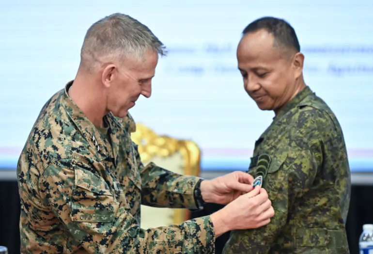 I Marine Expeditionary Force (I MEF) Commanding General and U.S. Marine Corps Lieutenant General Christian Wortman attaches the Balikatan patch to Philippine Exercise Director Francisco Lorenzo, during the opening ceremony of the U.S.-Philippines "Balikatan" joint military exercises at Camp Aguinaldo in Quezon City, Metro Manila, Philippines, April 20, 2026. REUTERS/Noel Celis