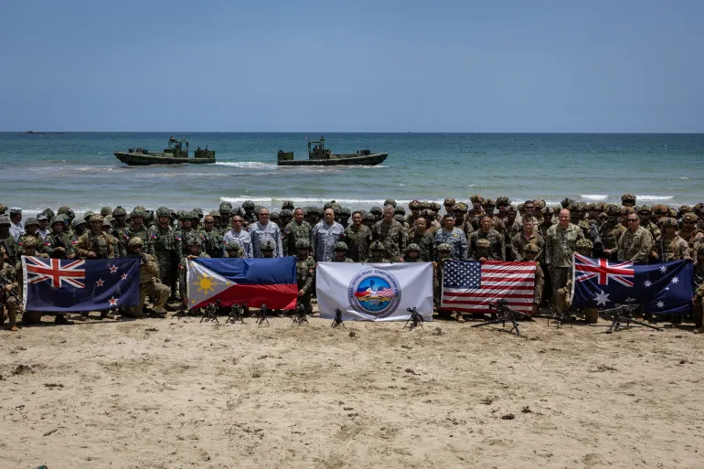 Troops from New Zealand, Philippines, U.S., and Australia pose for a photo with their national flags after participating in counter-landing live fire exercises during Balikatan, the annual joint military exercises between the U.S. and the Philippines, at Long Point Beach, Brgy. Aporawan, Aborlan, Palawan, Philippines, April 27, 2026. REUTERS/Eloisa Lopez