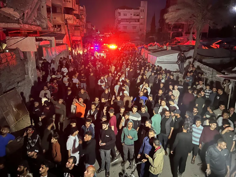Des gens se rassemblent autour d’un appartement résidentiel alors qu’un incendie brûle après un bombardement israélien