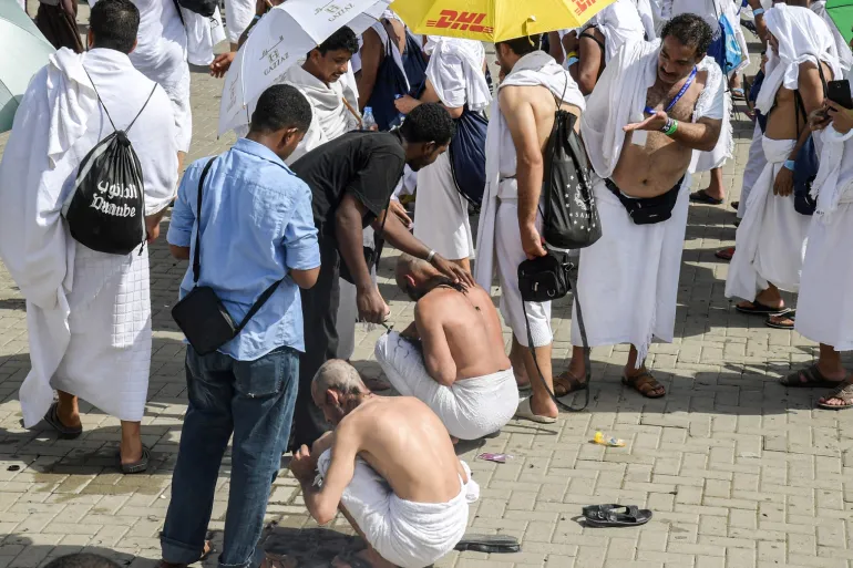 Des pèlerins musulmans se font raser la tête par des barbiers à leur sortie de Muzdalifah après avoir jeté des cailloux dans le cadre du symbolique al-Aqabah (rituel de lapidation du diable) sur le pont de Jamarat lors du pèlerinage du Hajj à Mina, près de la ville sainte de La Mecque en Arabie saoudite, le 11 août 2019. (Photo de FETHI BELAID / AFP)