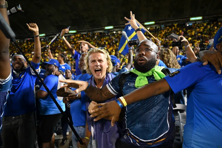 Les fans de Curaçao célèbrent la qualification pour la Coupe du monde 2026 après un match nul 0-0 avec la Jamaïque au Stade national de Kingston, en Jamaïque, le 18 novembre 2025. La petite nation caribéenne de Curaçao est devenue le plus petit pays à se qualifier pour la coupe du monde le 18 novembre alors qu'Haïti a réservé son retour au tournoi pour la première fois en 52 ans avec le Panama.