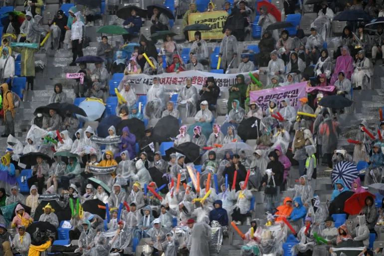 Des supporters sud-coréens applaudissent lors du match de football de demi-finale de la Ligue des champions féminine de l'AFC entre le Naegohyang Women's FC de Corée du Nord et le Suwon FC Women de Corée du Sud à Suwon, le 20 mai 2026. (Photo de JUNG YEON-JE / AFP)