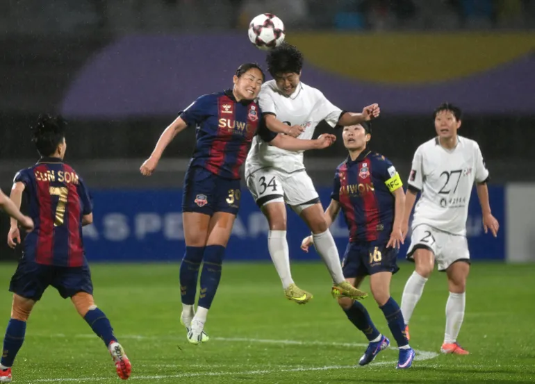 Pak Ye Gyong (au centre) du Naegohyang Women's FC se bat pour le ballon avec Haruhi Suzuki (2e à gauche) du Suwon FC Women lors du match de football demi-finale de la Ligue des champions féminine de l'AFC entre le Naegohyang Women's FC de Corée du Nord et le Suwon FC Women de Corée du Sud à Suwon le 20 mai 2026. (Photo de Jung Yeon-je / AFP)