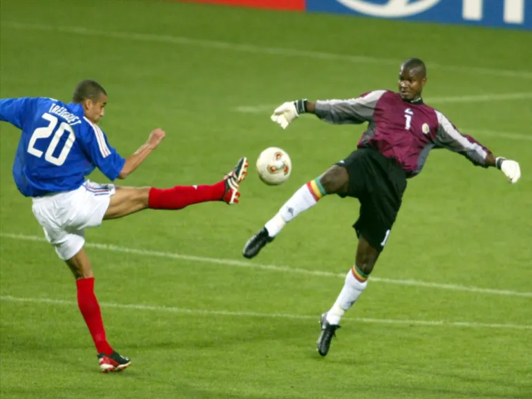 David Trezeguet en tant que joueur de football de la Coupe du Monde Nationale de France 2002 va chercher le ballon contre Tony Sylva du Sénégal