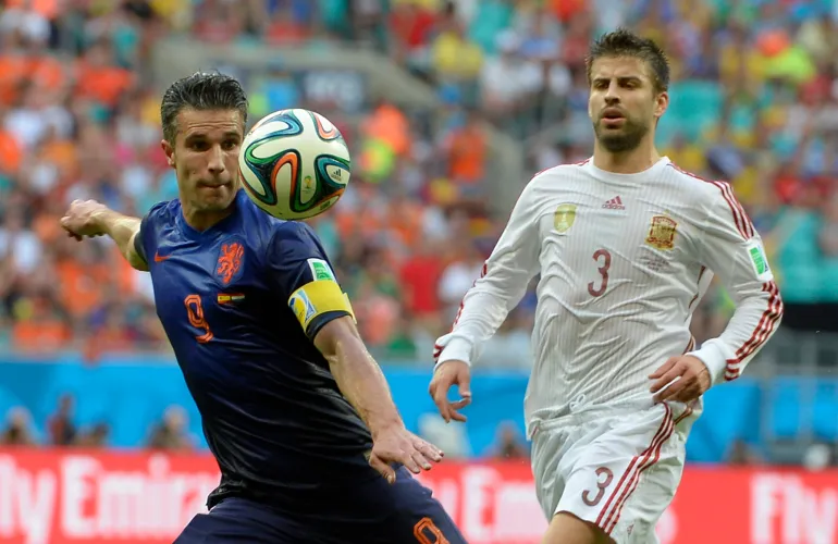 Robin van Persie, aux Pays-Bas, à gauche, se prépare à prendre une photo regardée par Gerard Pique, en Espagne, lors du match de football de la coupe du monde du groupe B