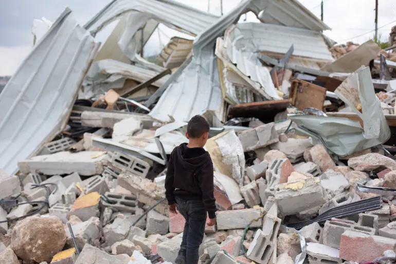 Young Musa Masallam walks through the rubble of Muhammad Masallam’s family home