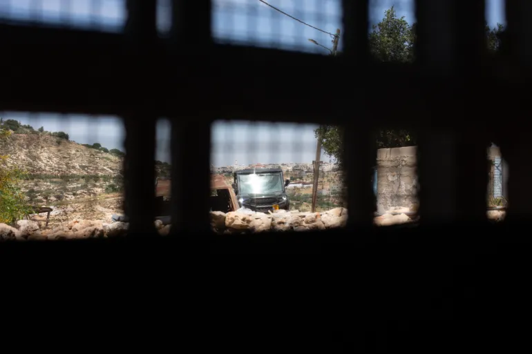 A settler ATV seen through the window of the Masallam home