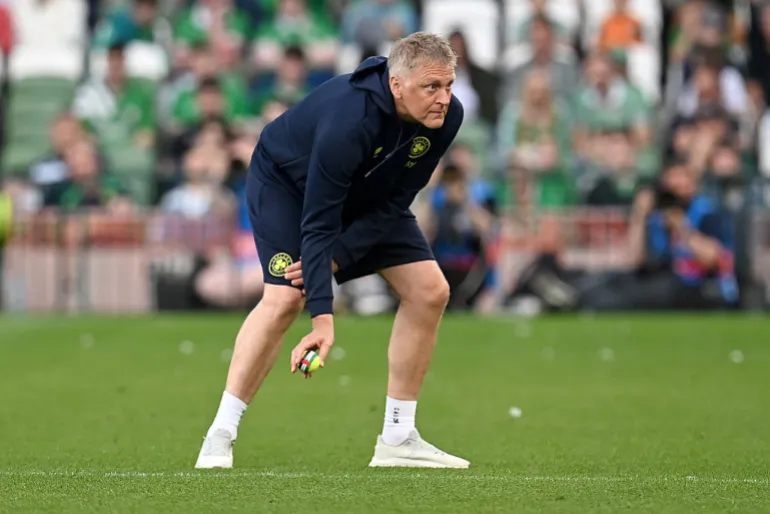 Heimir Hallgrimsson, entraîneur-chef de la République d'Irlande, aide à nettoyer les balles de tennis qui ont été lancées sur le terrain en signe de protestation contre un prochain match entre la République d'Irlande et Israël lors du match amical international entre la République d'Irlande et le Qatar.