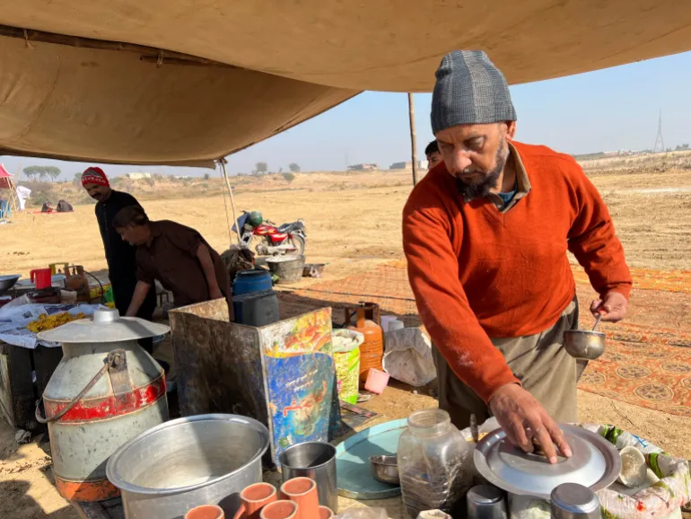A local vendor serves tea and savoury food items at in a mela [Mutee Ur Rehman/Al Jazeera]