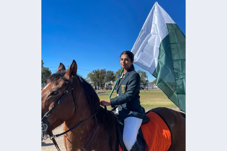 Ayesha Khan proudly holding Pakistan’s flag in South Africa at the Under-21 World Tent Pegging Championship 2023, the only girl in a team of four boys