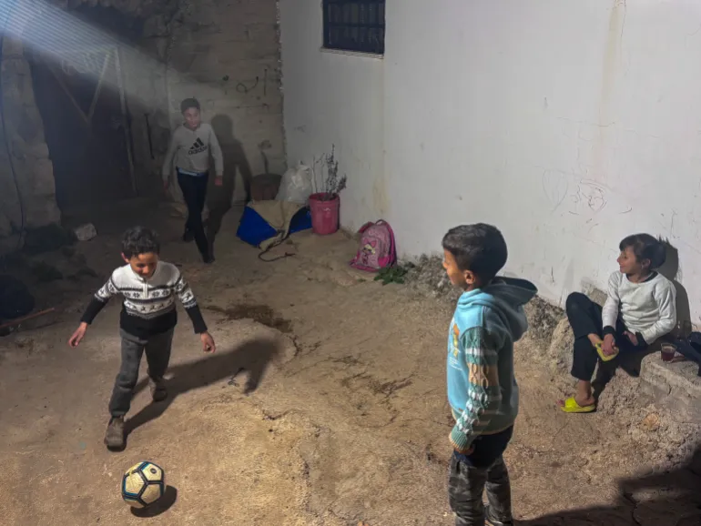Musa Masallam playing football with his cousins in the family home