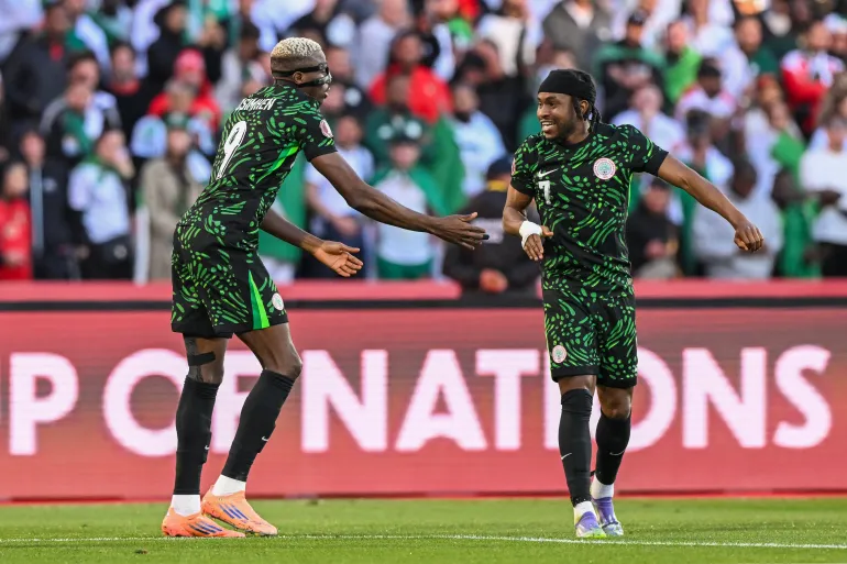 L'attaquant nigérian n°09 Victor Osimhen célèbre son but avec l'attaquant nigérian n°07 Ademola Lookman lors du quart de finale de la Coupe d'Afrique des Nations (CAN) entre l'Algérie et le Nigeria au Grand stade de Marrakech le 10 janvier 2026.
