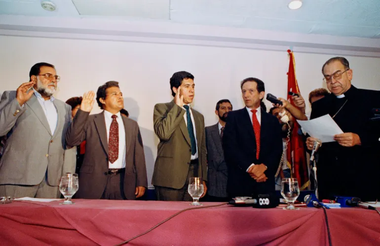 Members of the FMLN, including Schafik Hándal (L), are sworn in by Archbishop Arturo Rivera y Damas in San Salvador in 1992 as the group becomes a political party.