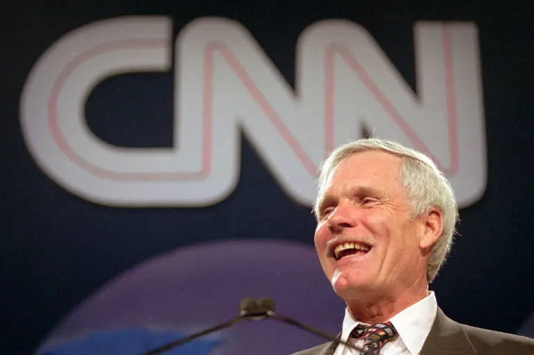 Ted Turner prend la parole lors d'un événement avec le logo de CNN en arrière-plan