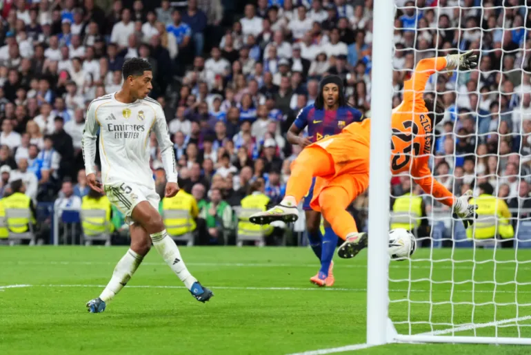 MADRID, ESPAGNE - 26 OCTOBRE : Jude Bellingham du Real Madrid marque le deuxième but de son équipe alors que Wojciech Szczesny du FC Barcelone ne parvient pas à faire une économie lors du match LaLiga EA Sports entre le Real Madrid CF et le FC Barcelone au stade Santiago Bernabeu le 26 octobre 2025 à Madrid, Espagne. (Photo par Angel Martinez/Getty Images)