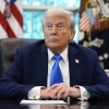 Le président Donald Trump écoute vendredi la question d'un journaliste dans le bureau ovale de la Maison Blanche.