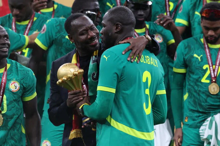 Le sélectionneur du Sénégal Pape Thiaw et Kalidou Koulibaly célèbrent avec le trophée après la finale de la Coupe d'Afrique des Nations au Maroc en janvier