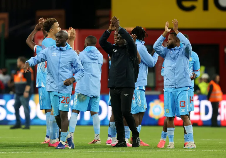 Meschack Elia, de la République démocratique du Congo, et les membres de l'équipe applaudissent les fans après le match