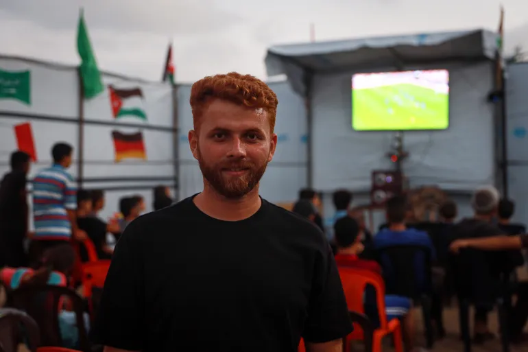 Tareq Al-Jadba a installé un café de fortune à l'intérieur du camp où il vit, permettant aux résidents déplacés autour de lui de regarder les matchs de la Coupe du monde. [Abdelhakim Abu Riash/ Al Jazeera]
