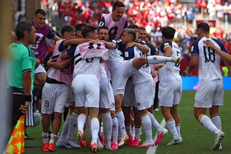 L'attaquant n°25 de Bosnie-Herzégovine, Jovo Lukic (caché), est félicité par ses coéquipiers après avoir marqué un but lors du match de football du groupe B de la Coupe du monde 2026 entre le Canada et la Bosnie-Herzégovine au Toronto Stadium, à Toronto, le 12 juin 2026. (Photo de Cole Burston / AFP)