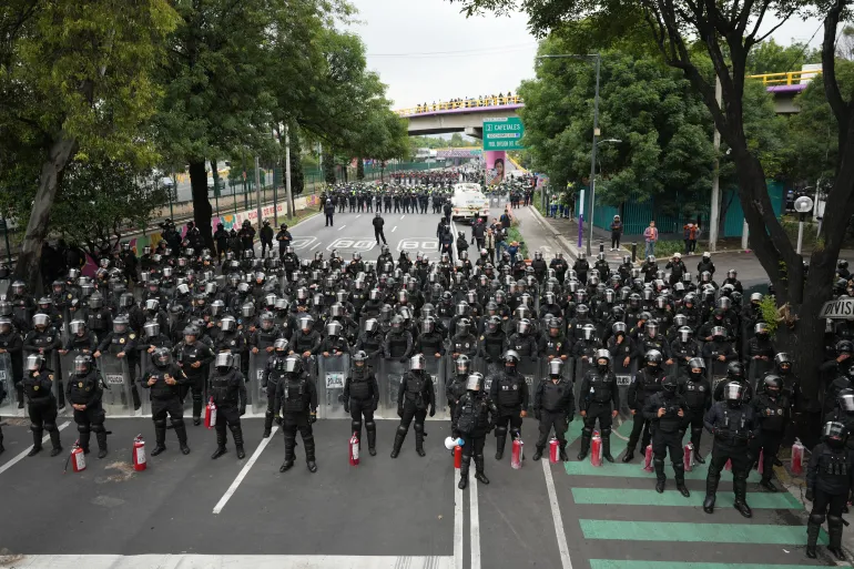 La police bloque une avenue pour empêcher les enseignants protestataires de se rendre au stade qui accueillera le match d'ouverture de la Coupe du Monde de la FIFA.