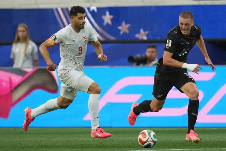 L'Iranien Mehdi Taremi (9 ans) dribble le ballon contre le Néo-zélandais Finn Surman (16 ans) lors du match de football du groupe G de la Coupe du monde entre l'Iran et la Nouvelle-Zélande à Inglewood, en Californie, près de Los Angeles, le lundi 15 juin 2026. (AP Photo/Andre Penner)