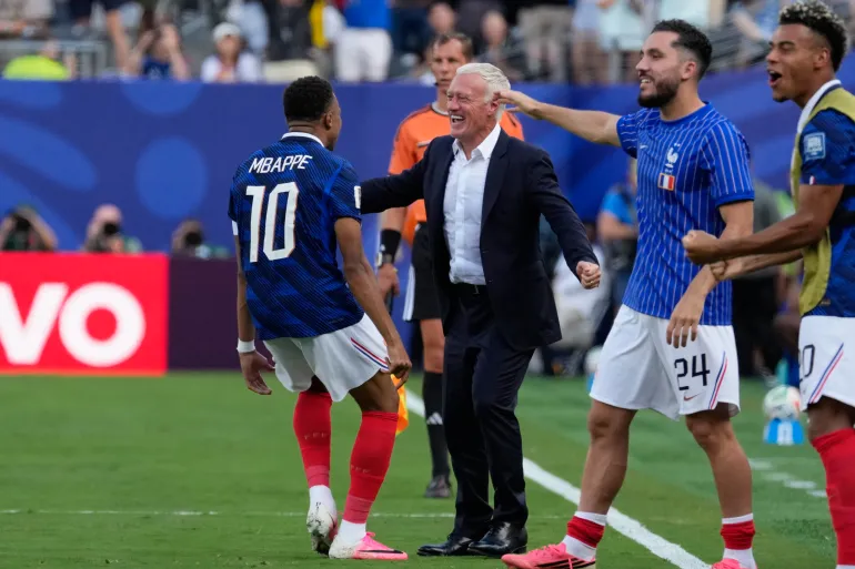 Le Français Kylian Mbappe, à gauche, célèbre avec son entraîneur Didier Deschamps après avoir marqué le premier but de son équipe lors des seizièmes de finale de la Coupe du monde de football entre la France et la Suède à East Rutherford, dans le New Jersey, près de New York, le mardi 30 juin 2026. (AP Photo/Seth Wenig)