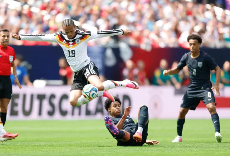 L'Allemand Leroy Sane saute par-dessus l'Américain Weston McKennie lors du match international de football amical entre les États-Unis et l'Allemagne au Soldier Field de Chicago, Illinois, le 6 juin 2026. (Photo de KAMIL KRZACZYNSKI / AFP)