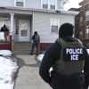 MINNEAPOLIS, MINNESOTA - 13 JANVIER : des agents de l'ICE s'approchent d'une maison avant d'arrêter deux personnes le 13 janvier 2026 à Minneapolis, Minnesota.