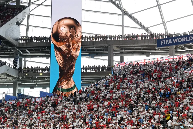 Les supporters anglais se tiennent dans les tribunes à côté d'un écran géant affichant le trophée avant les seizièmes de finale de la Coupe du monde 2026 de football entre l'Angleterre et la République démocratique du Congo au stade d'Atlanta à Atlanta, le 1er juillet 2026.