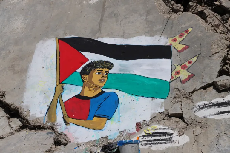 Une fresque peinte par des artistes palestiniens représente la star du football Lamine Yamal, qui a brandi un drapeau palestinien lors du défilé de la victoire de LaLiga à Barcelone, sur les décombres des bâtiments détruits pendant la guerre, au camp de réfugiés de Shati (plage), dans la ville de Gaza, le 13 mai 2026. REUTERS/Ebrahim Hajjaj