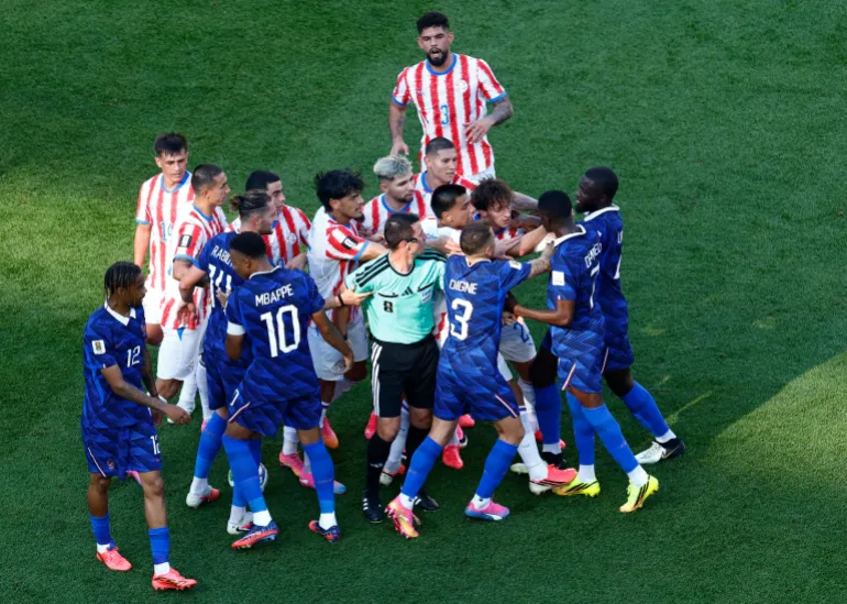 Le Français Ousmane Dembélé affronte des joueurs paraguayens après qu'Andres Cubas ait commis une faute sur Kylian Mbappe
