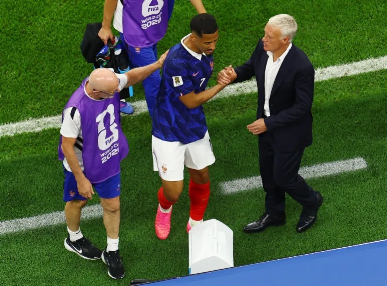 Football football - coupe du monde de la FIFA 2026 - semi finale - France / Espagne - Dallas Stadium, Arlington, Texas, États-Unis - 14 juillet 2026 William Saliba, de France, serre la main avec l'entraîneur Didier Deschamps après avoir subi une blessure et avoir été escorté hors du terrain REUTERS/Marco Bello
