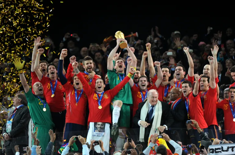 Le gardien de but espagnol Iker Casillas (au centre) soulève le trophée alors que les joueurs de l'équipe nationale espagnole de football célèbrent avec le président de la FIFA Sepp Blatter (5e R) et le président sud-africain Jacob Zuma (4e R) la victoire de la finale de la Coupe du monde de football 2010 Pays-Bas contre Espagne le 11 juillet 2010 au stade Soccer City de Soweto, dans la banlieue de Johannesburg. PAS DE PUSH VERS MOBILE / UTILISATION MOBILE UNIQUEMENT DANS L'ARTICLE ÉDITORIAL - PHOTO AFP / GABRIEL BOUYS (Photo de GABRIEL BOUYS / AFP)